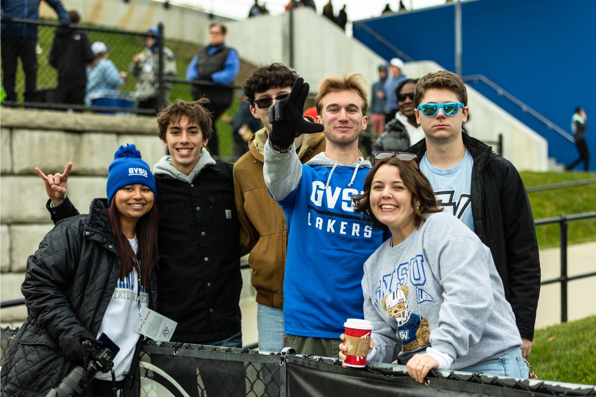 group of students posing for a picture waving and holding the anchor up sign